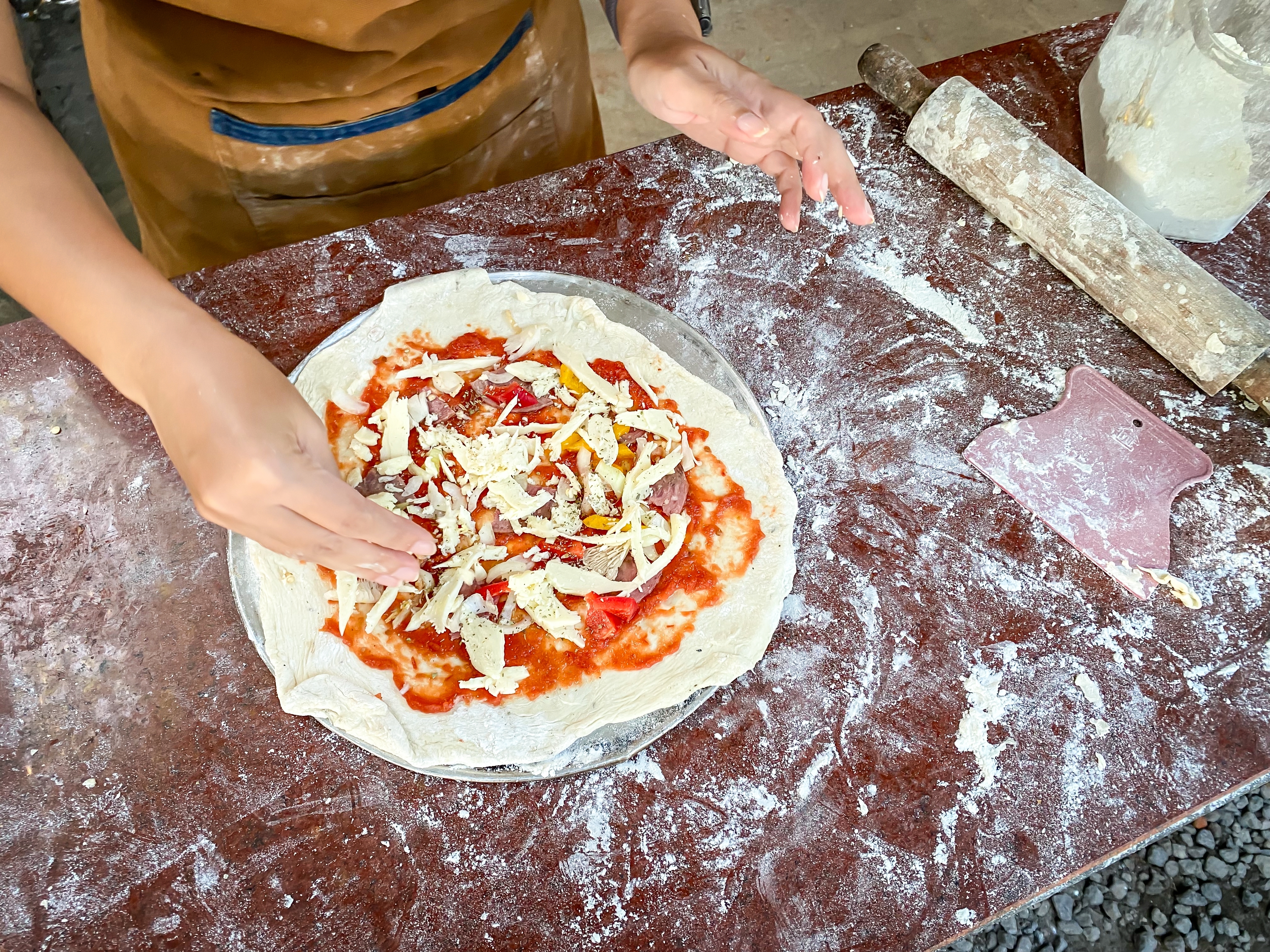 Woman wearing apron makes a pizza