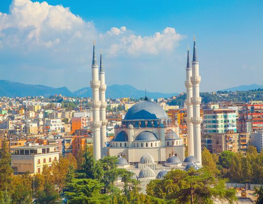 Skanderbeg square with flag, clock tower and The Et'hem Bey Mosque in the center of Tirana, Albania